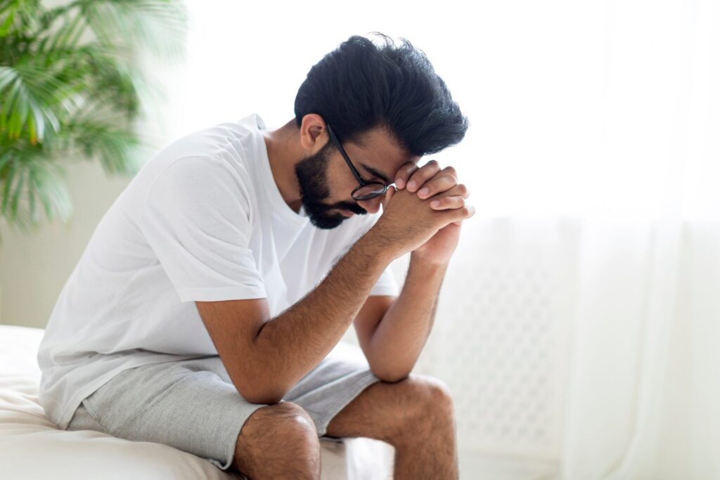 Impotence,Concept.,Upset,Pensive,Young,Indian,Man,Sitting,On,Bed