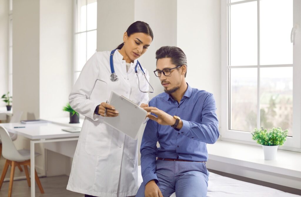 Doctor,And,Patient,Talking,During,Medical,Checkup,At,Clinic.,Young